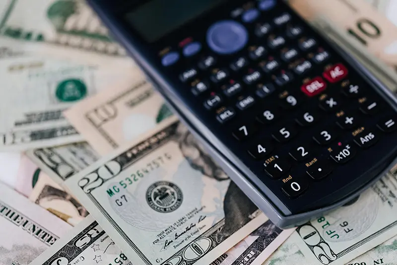 calculator laying on US dollar bills